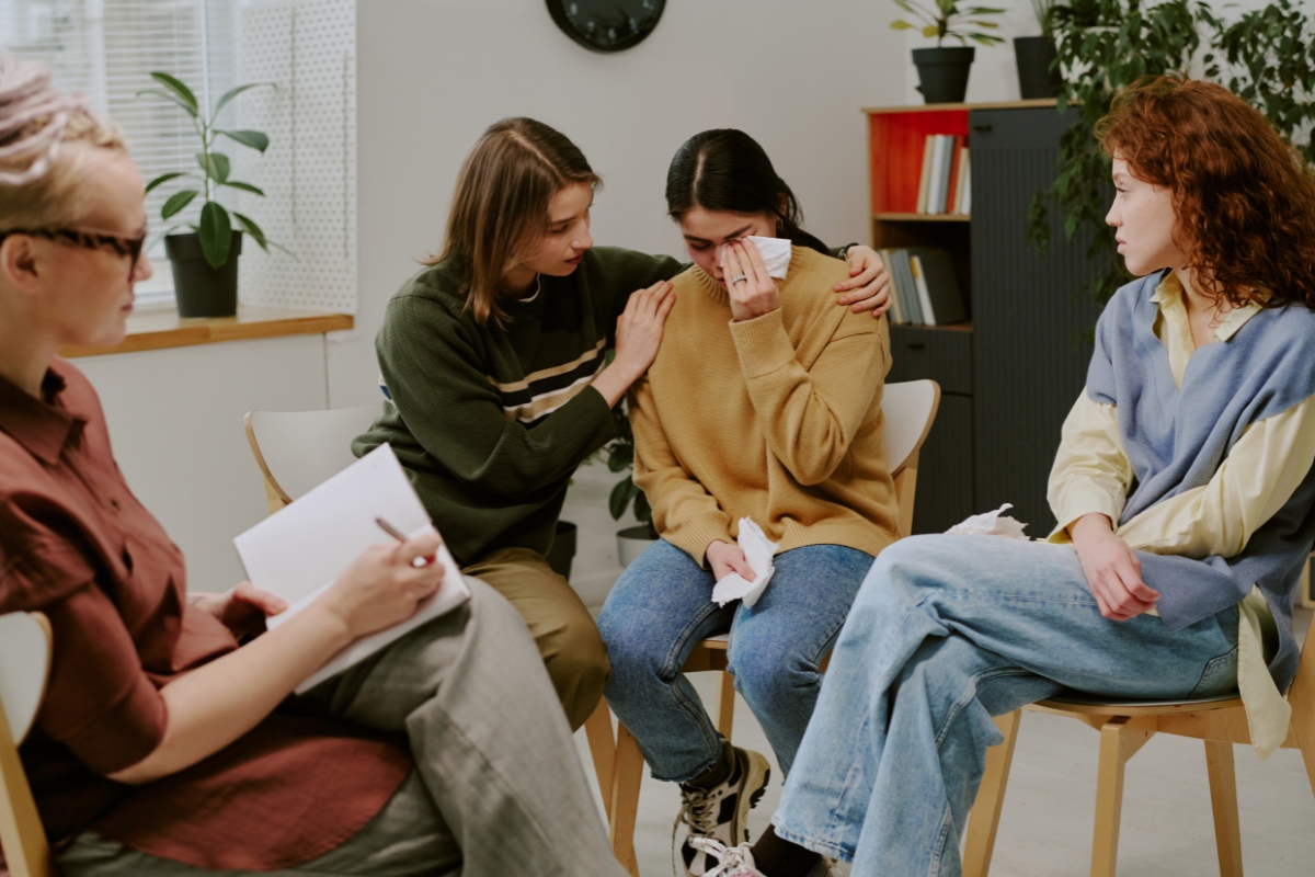 Support group therapy session with counselor helping a person dealing with depression in Cypress TX mental health clinic